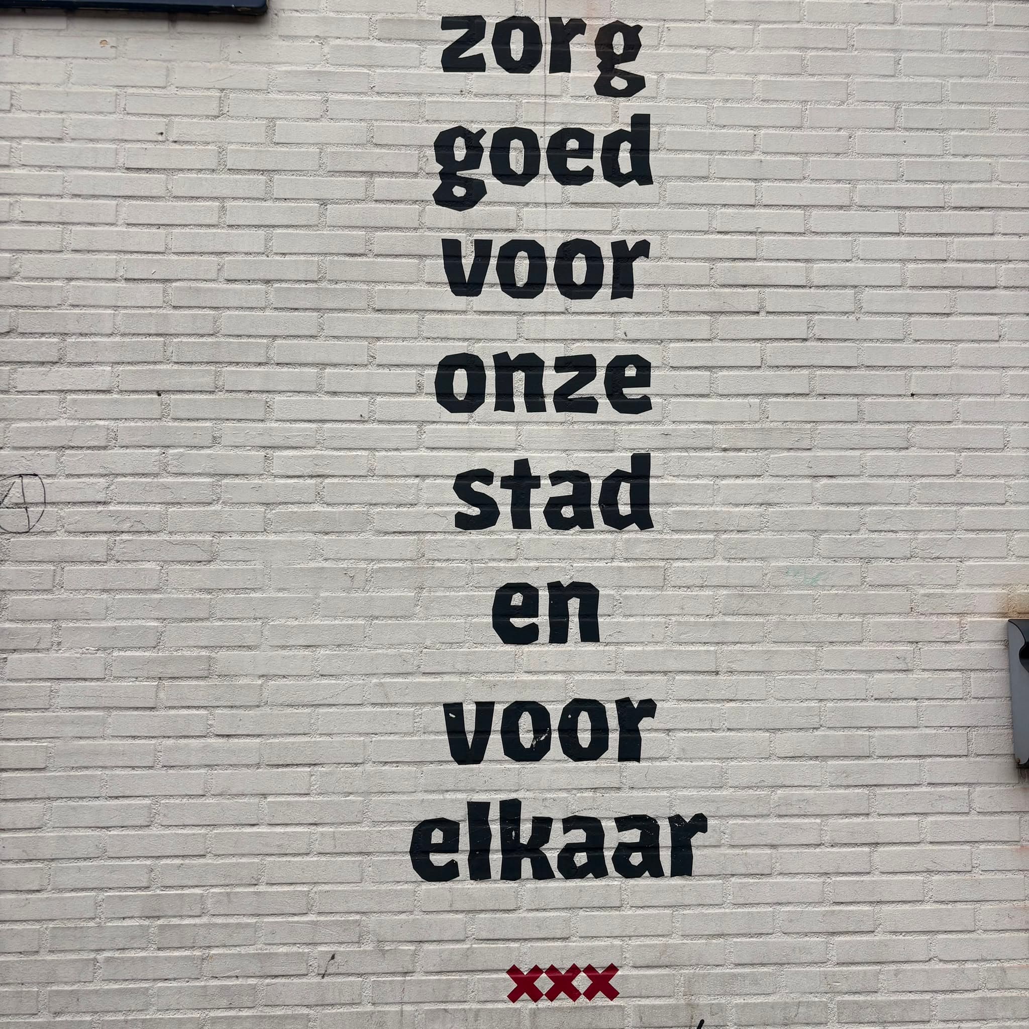 Muurtekst in Amsterdam: zorg goed voor onze stad en voor elkaar